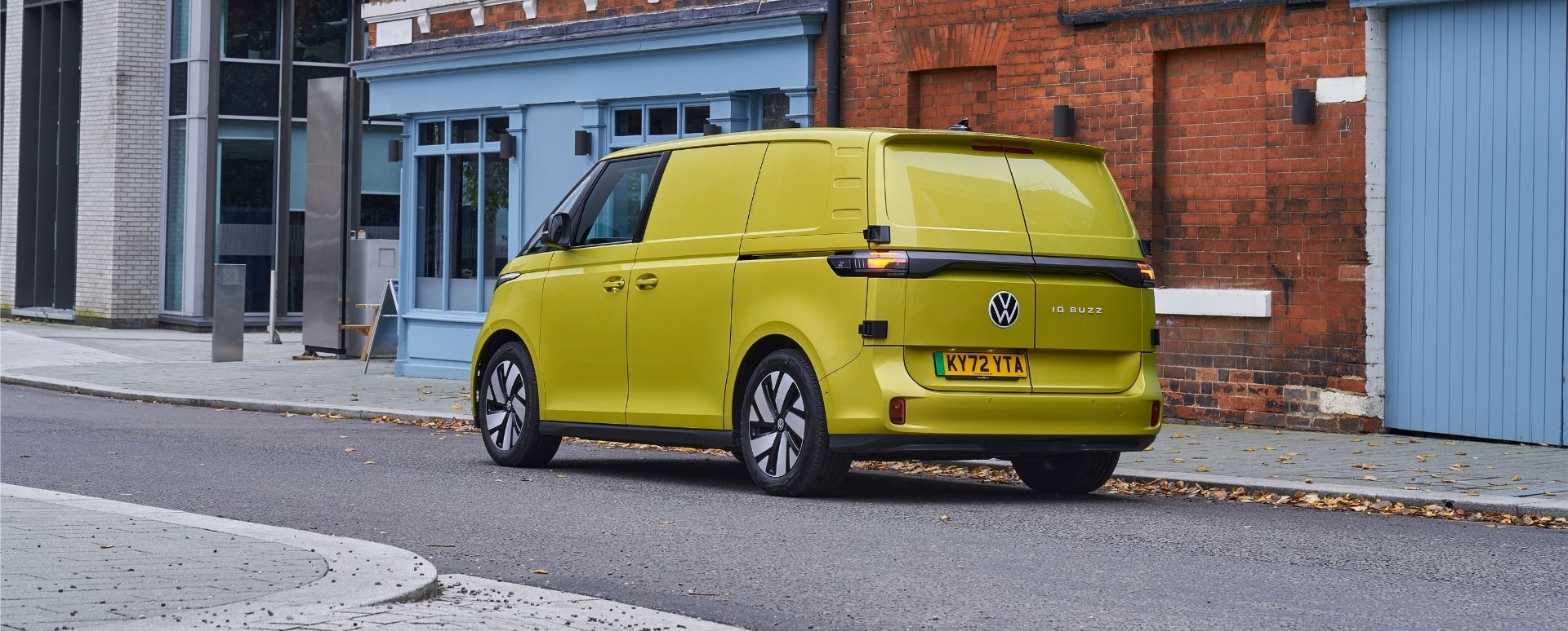Yellow VW Van Driving Down Residential Road