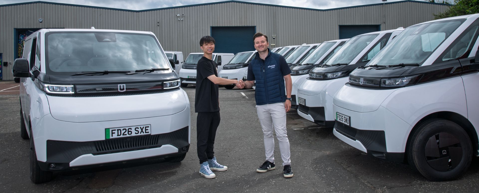 Two Men Shaking Hands Amongst Farizon Vans Fleet