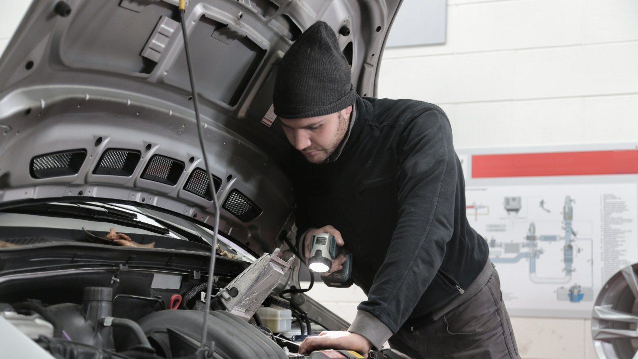 Man Working On Open Bonnet Of Car