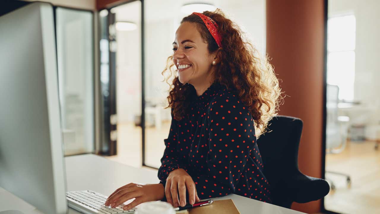 Woman Sat At Desk On Computer